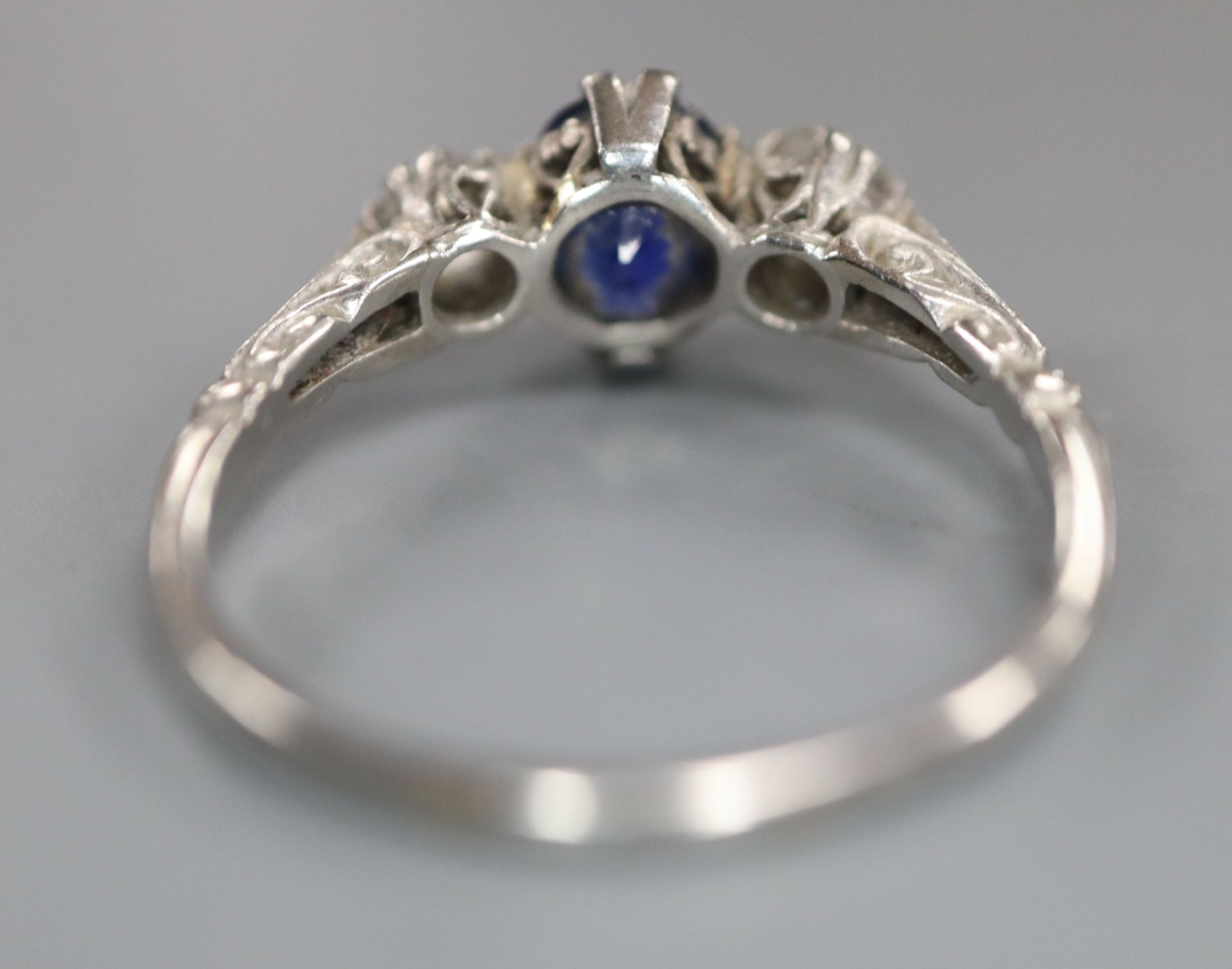 A mid 20th century white metal, sapphire and diamond three stone ring, size P, gross 3.6 grams.